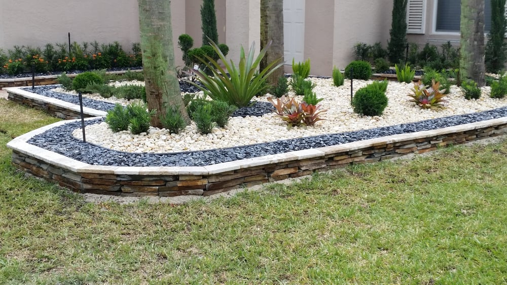 Front bed with stacked stone edge and tropical plants